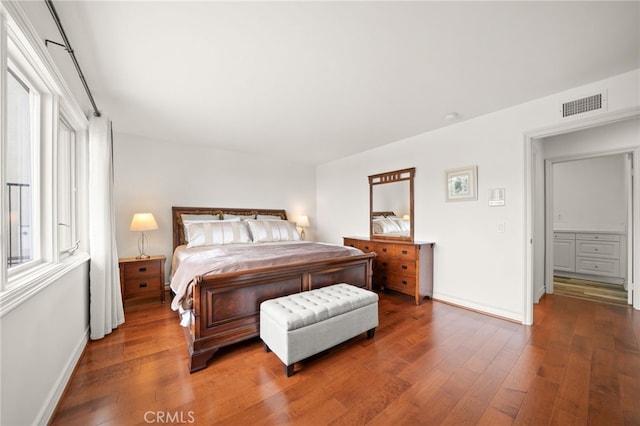 bedroom with baseboards, wood-type flooring, and visible vents
