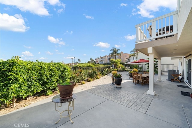 view of patio / terrace featuring fence, outdoor dining space, and a balcony