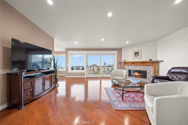 living room with baseboards, a fireplace, recessed lighting, and wood finished floors