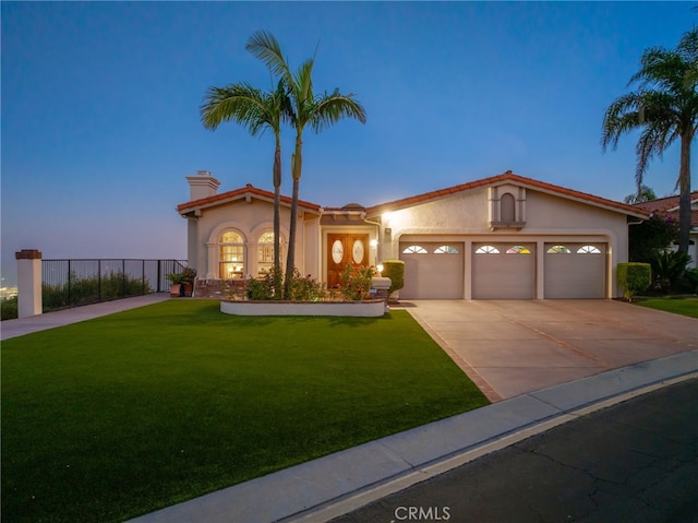 mediterranean / spanish-style home with a yard and a garage