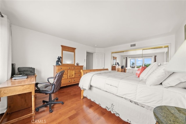 bedroom featuring visible vents and wood finished floors