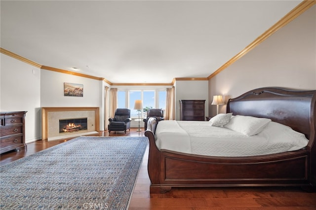 bedroom featuring crown molding, a glass covered fireplace, and wood finished floors