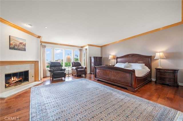 bedroom with wood-type flooring, baseboards, ornamental molding, and a high end fireplace