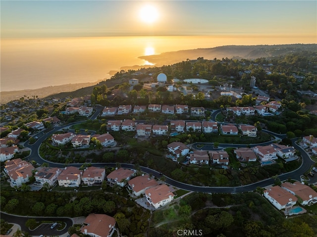 aerial view at dusk featuring a mountain view and a residential view