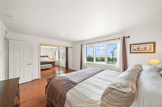 bedroom featuring a closet, visible vents, and wood finished floors