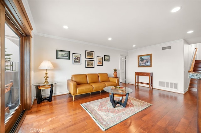 living room featuring ornamental molding and light hardwood / wood-style floors