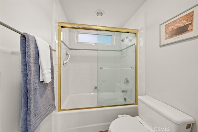 bathroom featuring combined bath / shower with glass door and toilet