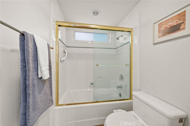 bathroom featuring combined bath / shower with glass door and toilet