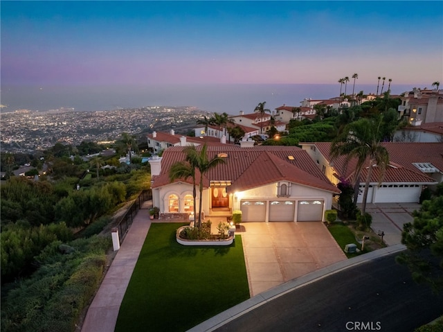 mediterranean / spanish house featuring a lawn and a garage