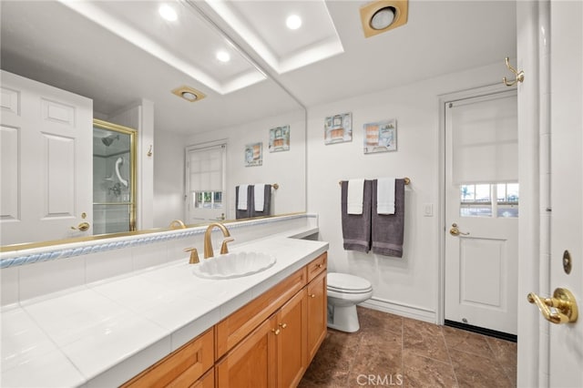 bathroom with walk in shower, vanity, and toilet