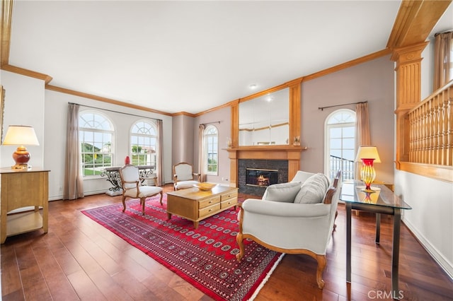 living room featuring crown molding, hardwood / wood-style flooring, a fireplace with flush hearth, and plenty of natural light