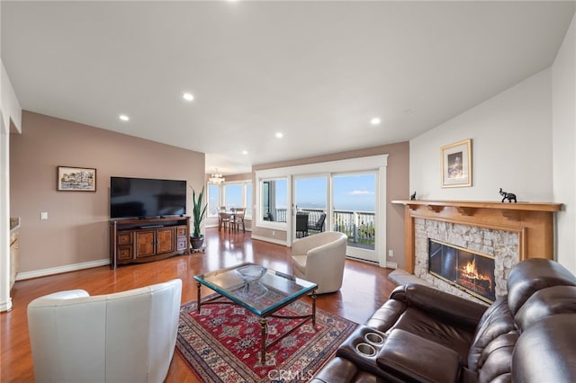 living room with hardwood / wood-style flooring, lofted ceiling, and a fireplace