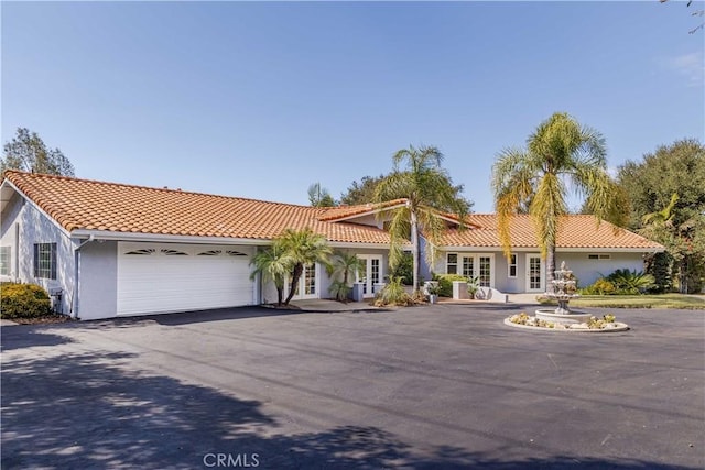 mediterranean / spanish home featuring french doors and a garage