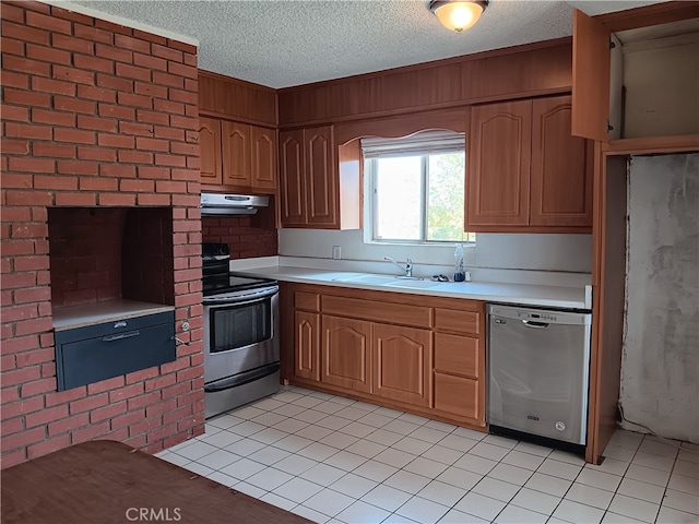 kitchen featuring appliances with stainless steel finishes, a textured ceiling, sink, and light tile patterned flooring