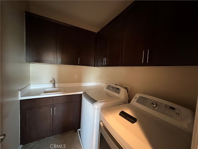 washroom featuring separate washer and dryer, cabinets, sink, and light tile patterned flooring