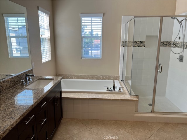 bathroom featuring shower with separate bathtub, vanity, and tile patterned floors