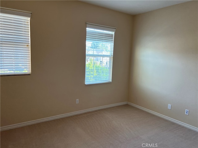 carpeted spare room featuring plenty of natural light