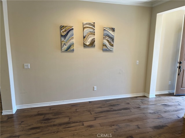 empty room with crown molding and dark wood-type flooring