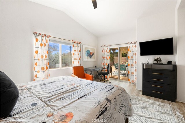 bedroom with access to outside, vaulted ceiling, multiple windows, and light hardwood / wood-style floors