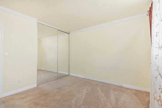 unfurnished bedroom featuring ornamental molding, light colored carpet, and a closet