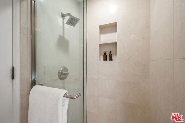 bathroom with a shower with door