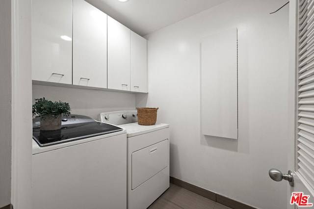 washroom with separate washer and dryer and cabinets