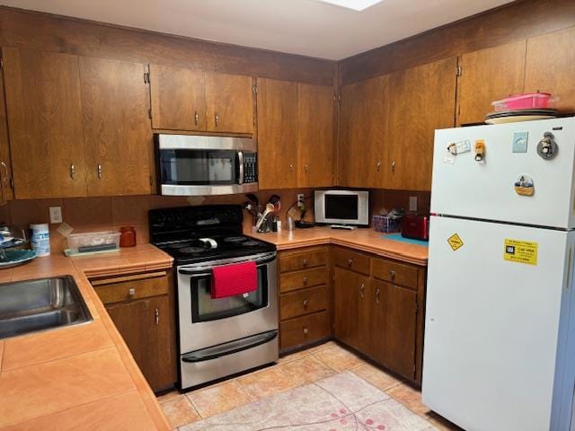 kitchen featuring light tile patterned floors, decorative backsplash, sink, and appliances with stainless steel finishes