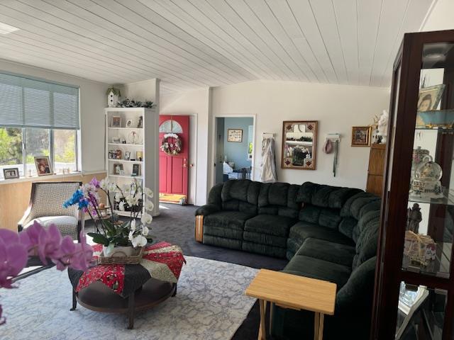 living room with wood ceiling, lofted ceiling, and carpet flooring