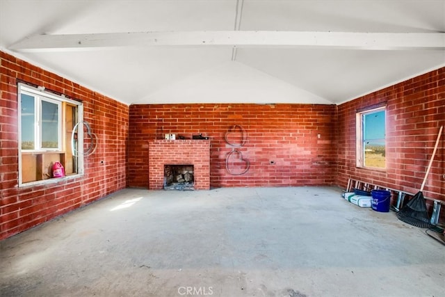 unfurnished living room with brick wall, lofted ceiling with beams, and concrete flooring