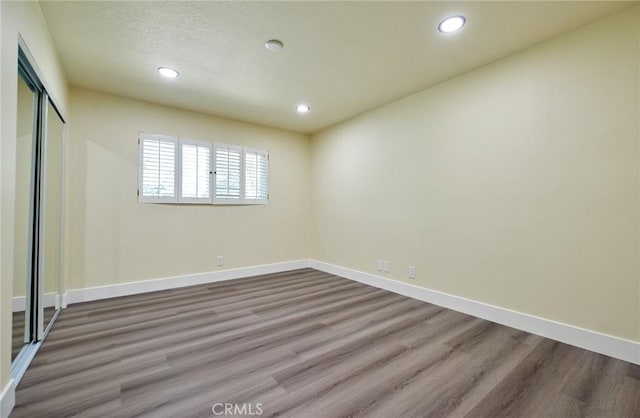 empty room featuring wood-type flooring and a textured ceiling