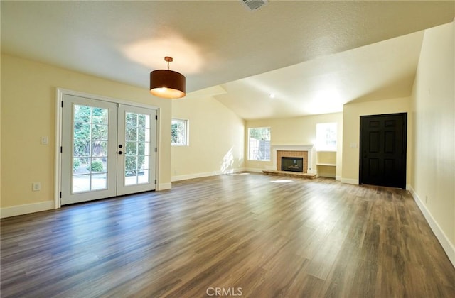 unfurnished living room featuring french doors, dark wood-type flooring, a wealth of natural light, and lofted ceiling