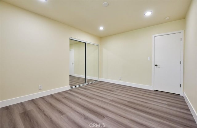 unfurnished bedroom with wood-type flooring and a closet