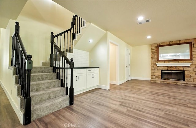 interior space with a stone fireplace and hardwood / wood-style flooring