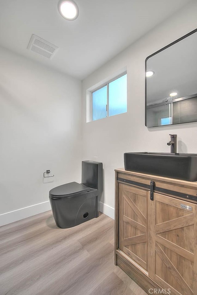 bathroom with vanity, hardwood / wood-style flooring, and toilet