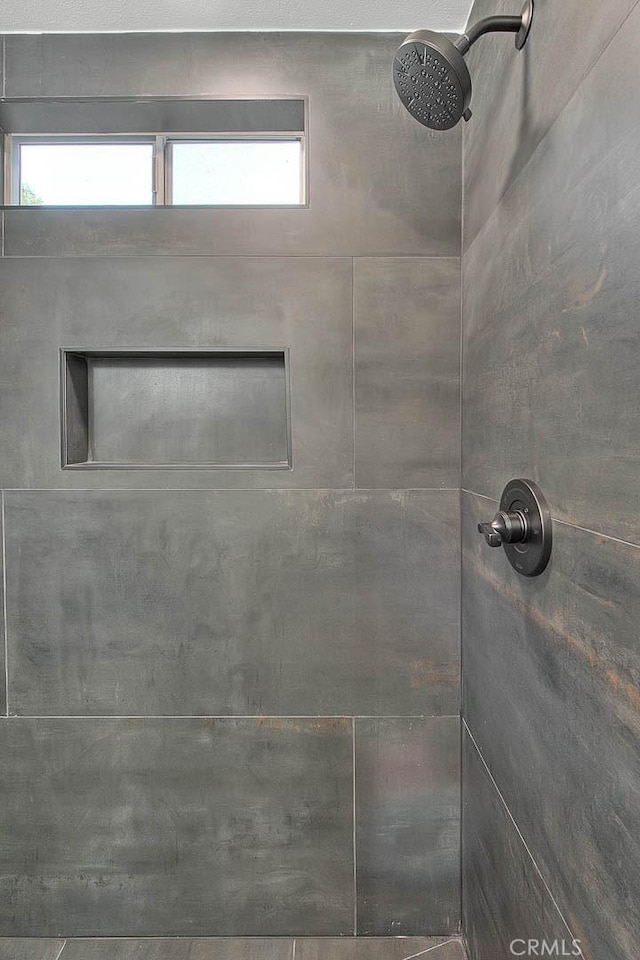 bathroom with a healthy amount of sunlight and a tile shower