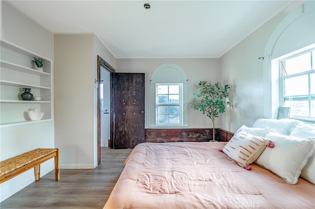 bedroom with crown molding and hardwood / wood-style floors