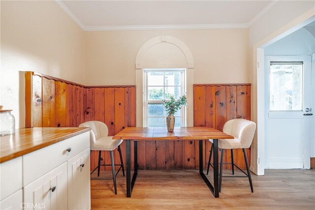 dining space featuring ornamental molding and light wood-type flooring