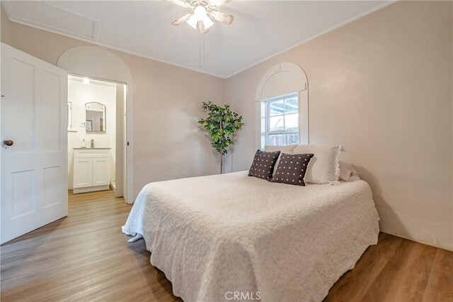 bedroom featuring ornamental molding, hardwood / wood-style flooring, ceiling fan, and ensuite bathroom