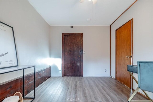 interior space featuring ceiling fan, ornamental molding, and light hardwood / wood-style floors