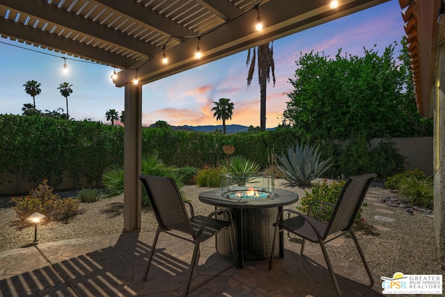 patio terrace at dusk featuring a pergola