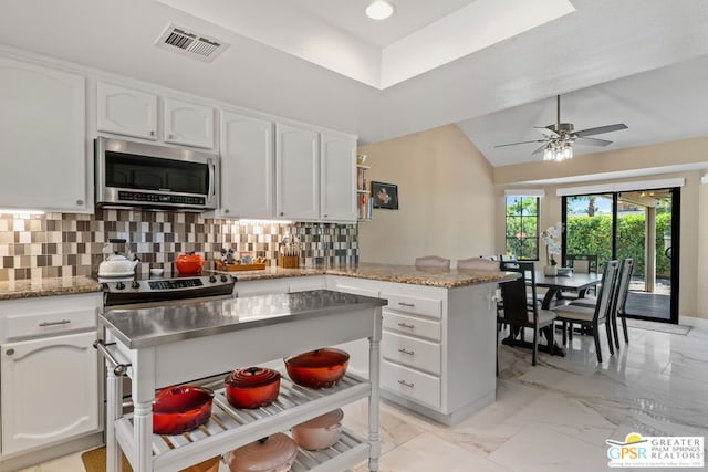 kitchen featuring white cabinets, decorative backsplash, ceiling fan, and appliances with stainless steel finishes