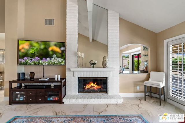 living room featuring vaulted ceiling and a brick fireplace