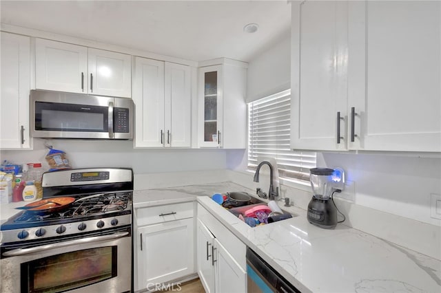 kitchen with white cabinets, appliances with stainless steel finishes, and sink