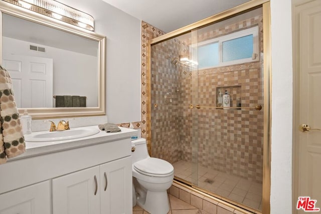 bathroom featuring walk in shower, vanity, toilet, and tile patterned floors