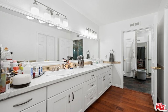 bathroom featuring wood-type flooring, vanity, and toilet