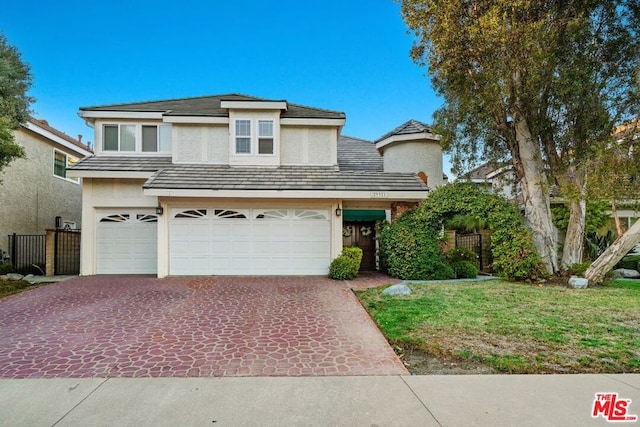 view of front of house featuring a garage and a front lawn