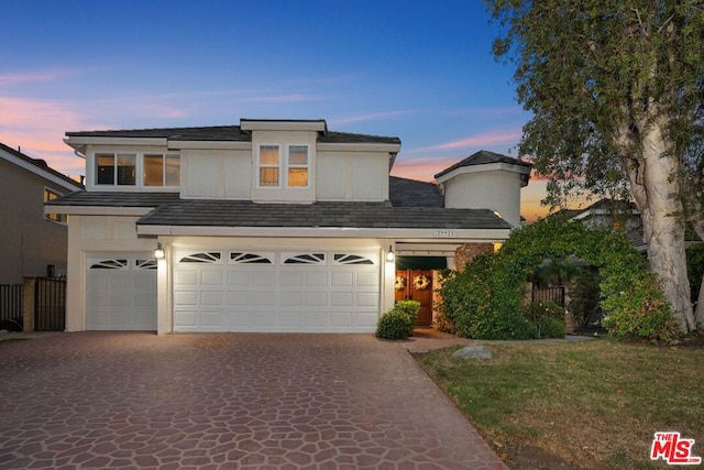 front facade featuring a yard and a garage