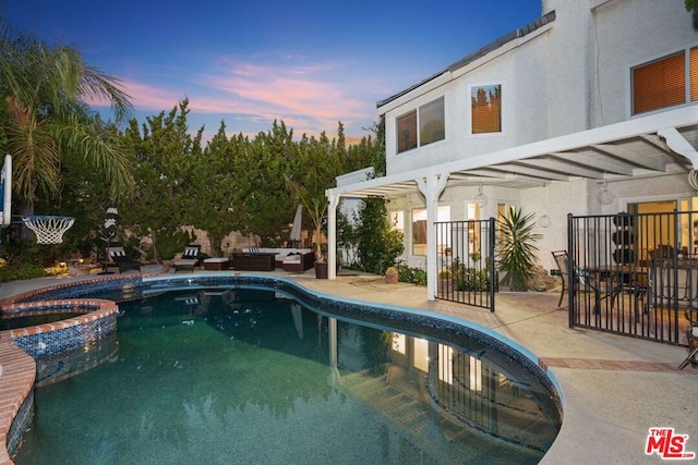 pool at dusk with a patio, a pergola, and an in ground hot tub