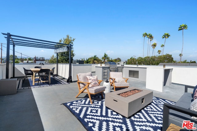 view of patio / terrace featuring a pergola, area for grilling, an outdoor fire pit, and exterior kitchen