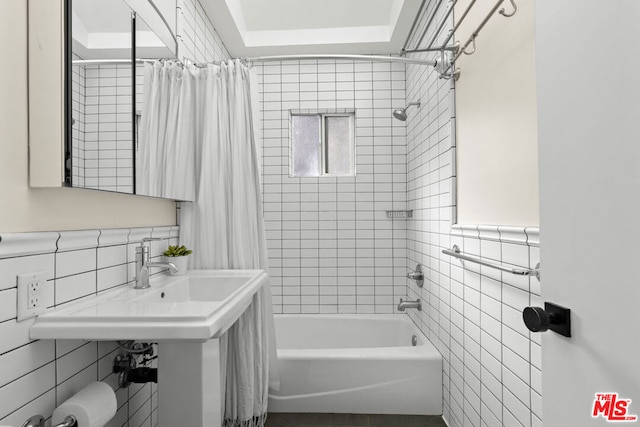 bathroom with shower / bath combo and tile walls